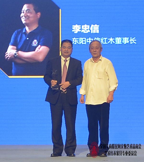 古典家具传承工艺大师王秀林（左）为东阳中信红木董事长李忠信颁奖